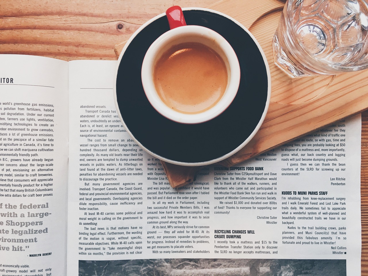 Tazza di caffè su una scrivania con un giornale aperto, rappresenta il momento di lettura e analisi delle notizie.